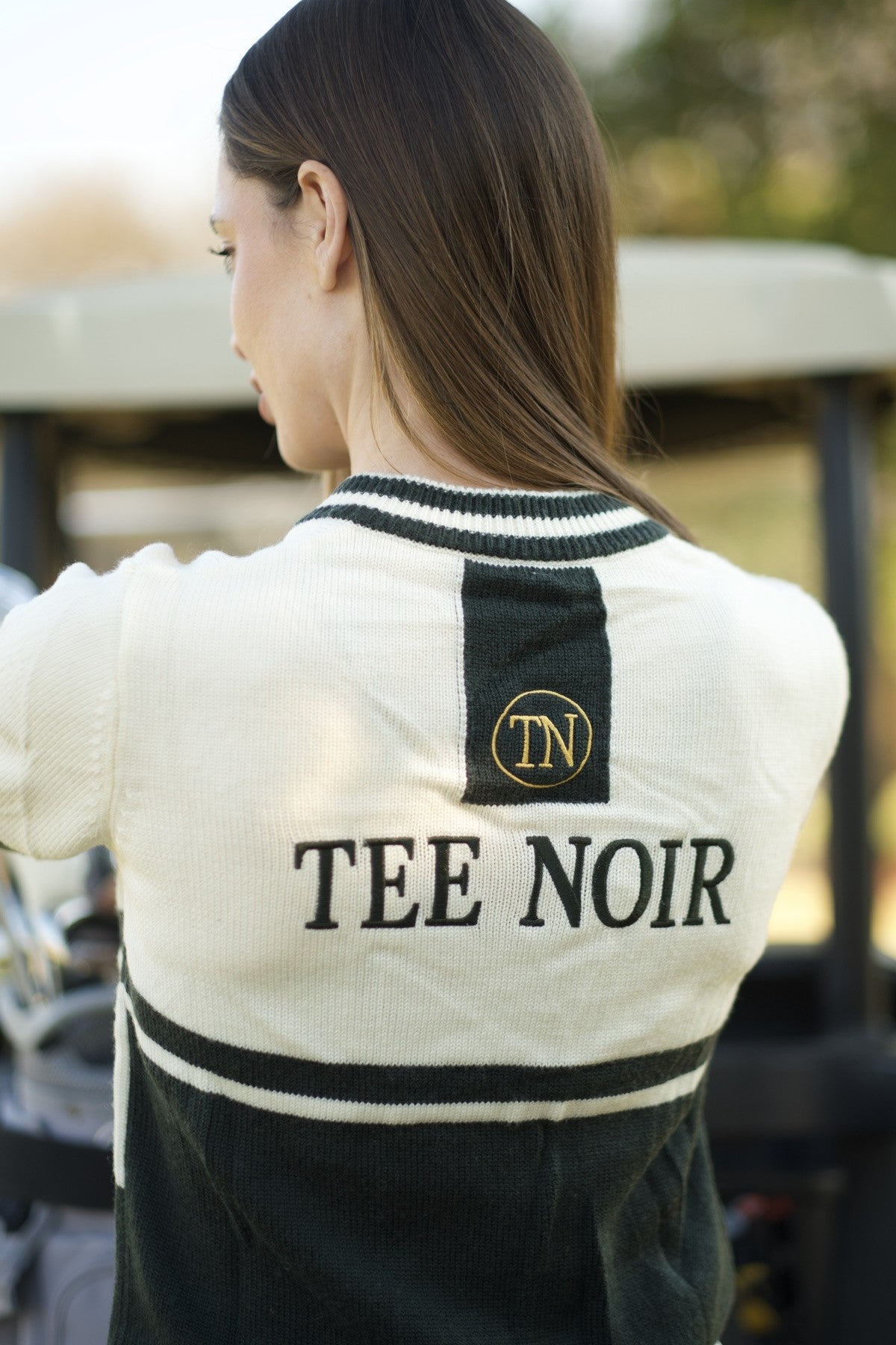 Tee Noir — the Fleetwood Cardigan worn on the course, TEE NOIR knit across the back